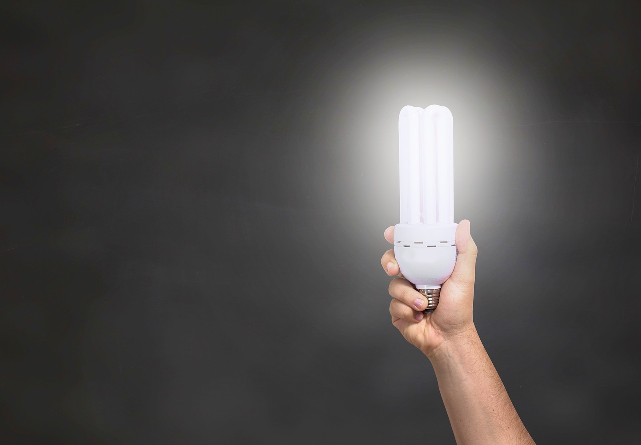 Lâmpada LED acesa num candeeiro moderno com luz quente e eficiente