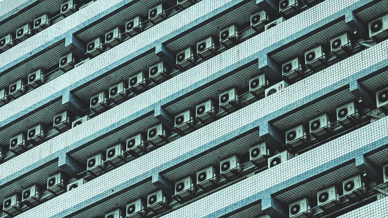 Técnico a realizar manutenção preventiva de equipamento de climatização em edifício português
